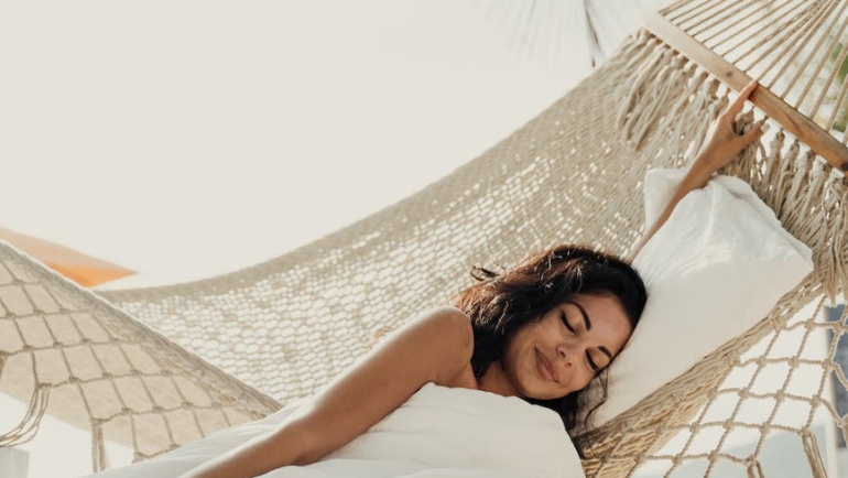 woman lying beside a hammock