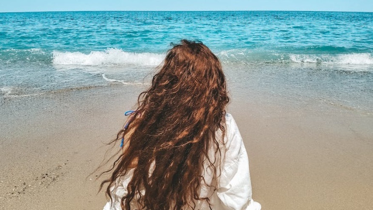 sitting on beach woman looking at sea