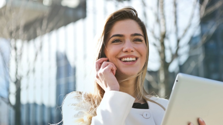 woman in white blazer holding tablet computer