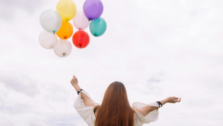 Doing new things, a woman releases balloons to celebrate.